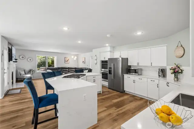 Gourmet Kitchen with Open Flow - beautifully updated kitchen with quartz waterfall countertops, large island with gas cooktop, and Kitchenaid stainless steel appliances. The open-concept design seamlessly connects to the family room, making it ideal for entertaining and everyday living.