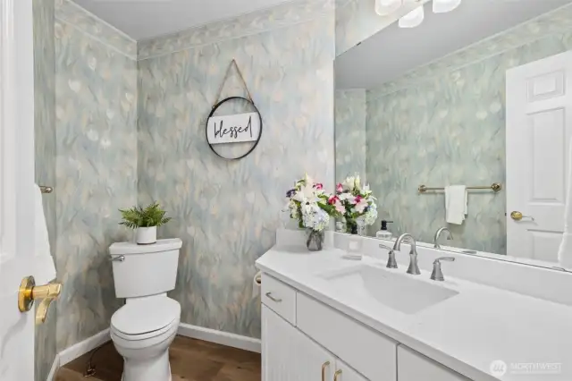 Stylish Main Floor Powder Room. Charming half bath with custom floral wallpaper, quartz countertop, and elegant fixtures. Conveniently located on the main floor—perfect for guests and everyday use with a touch of personality.