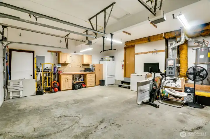 Along with parking spaces, the attached, 2-car garage offers built-in shelving, cabinets, a workbench, and pegboard. You'll also find a chest freezer and additional freezer-fridge, and the water heater, furnace, and electrical panel in here for easy access.