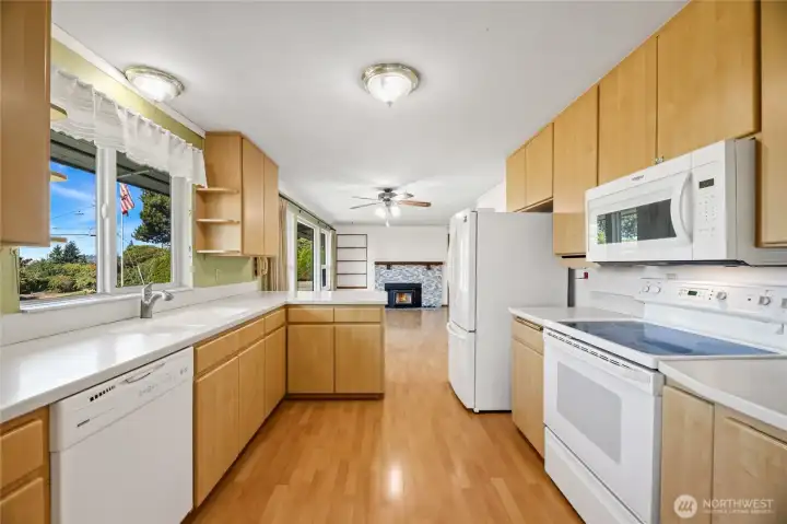 KITCHEN  White appliances – refrigerator, flat top stove, dishwasher, and microwave  Corian counters / Custom knife organizer  Peninsula with extra counter space and storage cabinets  Tall upper cabinets to maximize space  Window to front with views of Olympic Mountains, Maury Island and Puget Sound