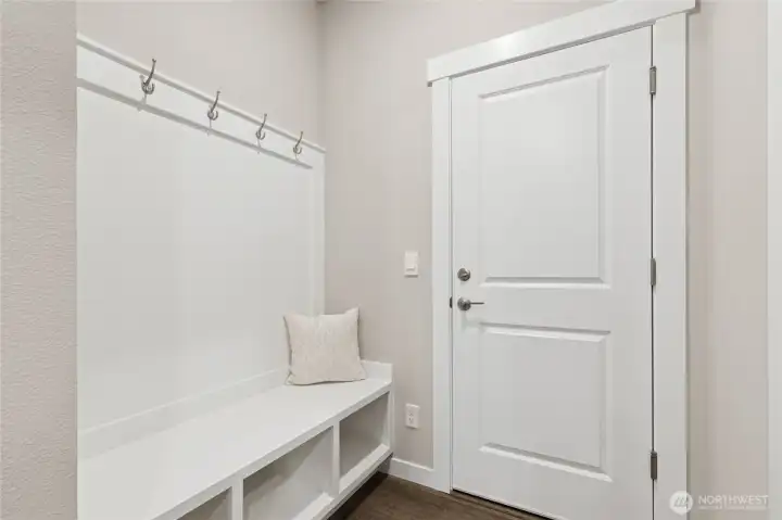 Built-in drop zone with bench shoe storage and coat hangers as you enter the home from the gagage.  Materials, colors, and finishes will vary. See site agent for details.