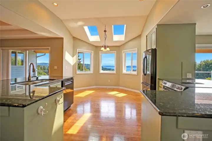 Inviting kitchen space featuring skylights, hardwood floors, and sweeping views.