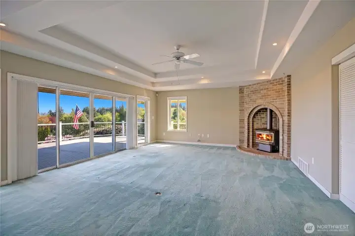 Expansive living room with cozy fireplace and direct access to covered deck.