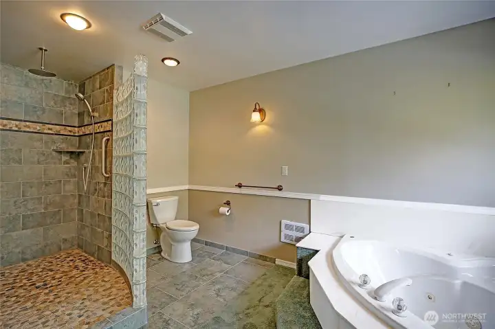 Generous bathroom space with custom tile shower.