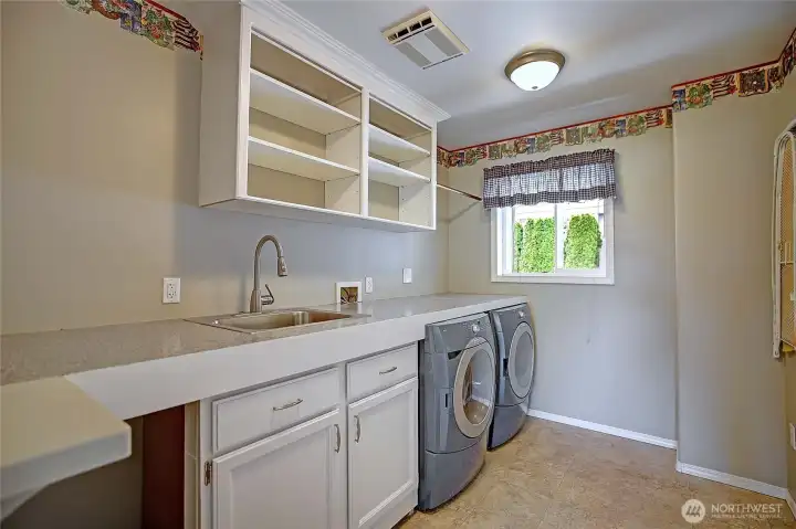 Utility room with sink, storage, and plenty of counter space.