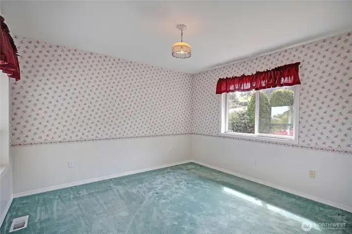 Additional guest bedroom with natural light and garden views.