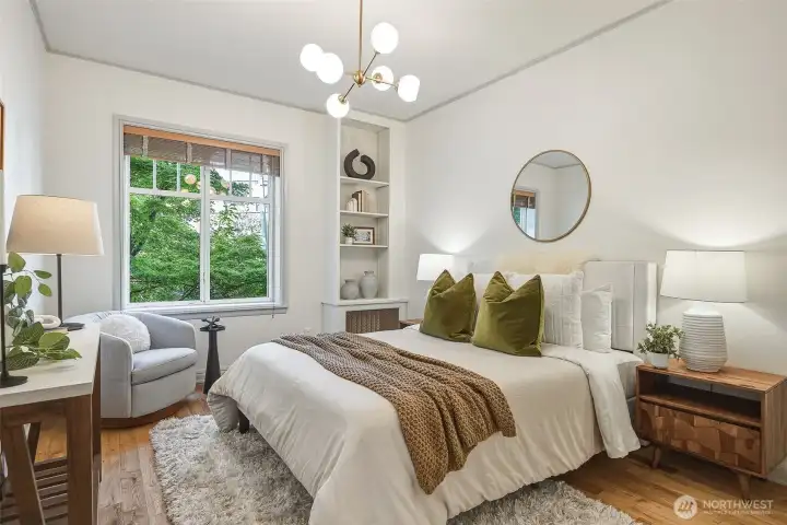 Your lofty bedroom features a tall window & designer chandelier.