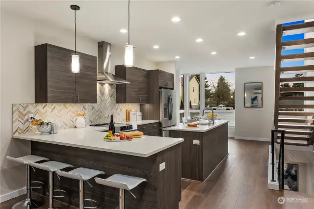 Large kitchens in both plans.  Each kitchen features BOTH an island AND peninsula + stainless appliance package + stone backsplash + quartz-topped counters + amazing storage + under cabinet lighting + separate dining spaces.