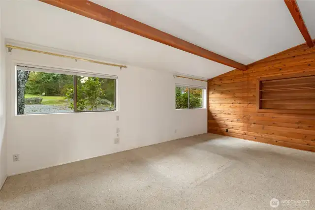 The primary bedroom features vaulted ceilings, and built-in book shelves.