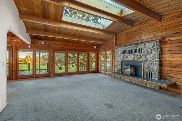 The spacious and bright living room with skylights, vaulted ceilings and a cozy fire place.