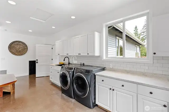 What a laundry room! Deep sink, storage, counters for folding laundry, customized bench and access to the junior suite.