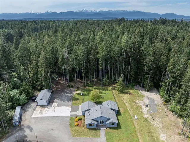 Rambler with 3 bdrms (2 suites) detached 4 car garage, 4.89 acres, an orchard, pickelball/sport court and great privacy!