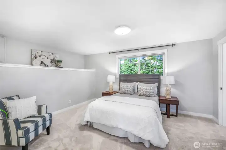 The spacious primary suite is designed as a restful retreat. Soft natural light streams in through the window, enhancing the room’s sense of calm and comfort.