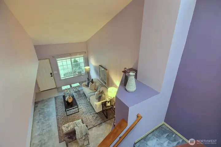 This birds-eye view from the upper level landing highlights the impressive vaulted ceilings and the expansive, open-concept layout which offers a perfect blend of modern height and cozy comfort.