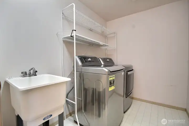The large laundry room is conveniently located on the upper level and features a utility tub sink for those extra clean-ups and shelving unit which stays.