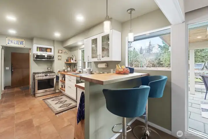 Updated kitchen with chefs dream gas stove and breakfast bar