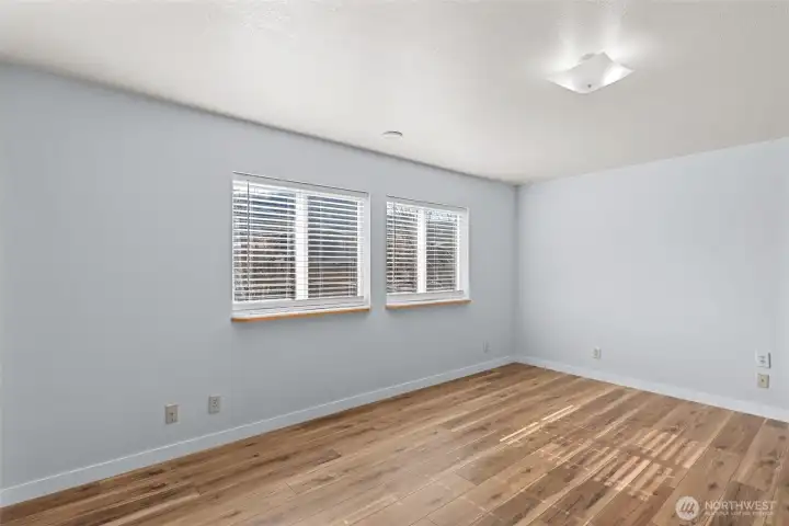 Primary bedroom lets in great natural lighting and new flooring