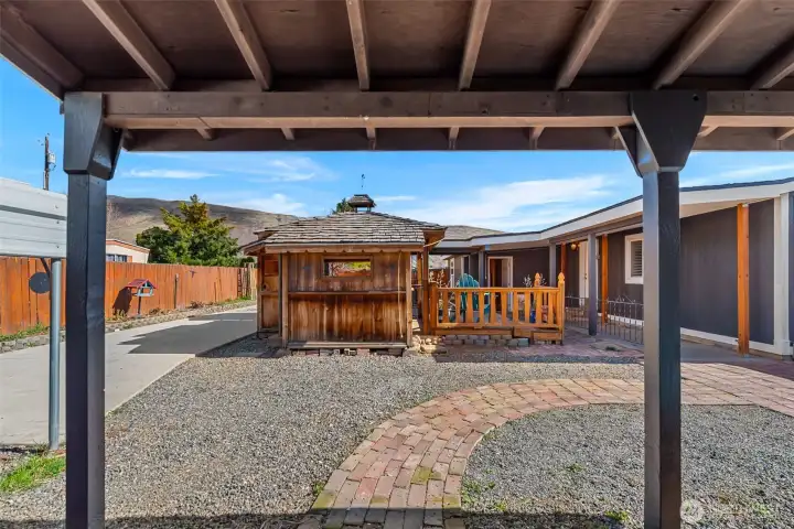 Porch from outbuilding, looking over the driveway and graveled back yard space