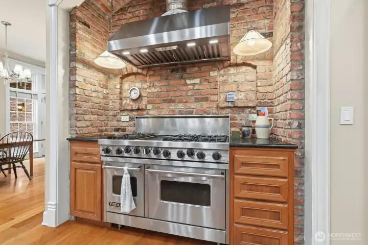 Brick niche surrounding Viking Stove with 6 burners, griddle, 2 ovens and Zephyr Hood.