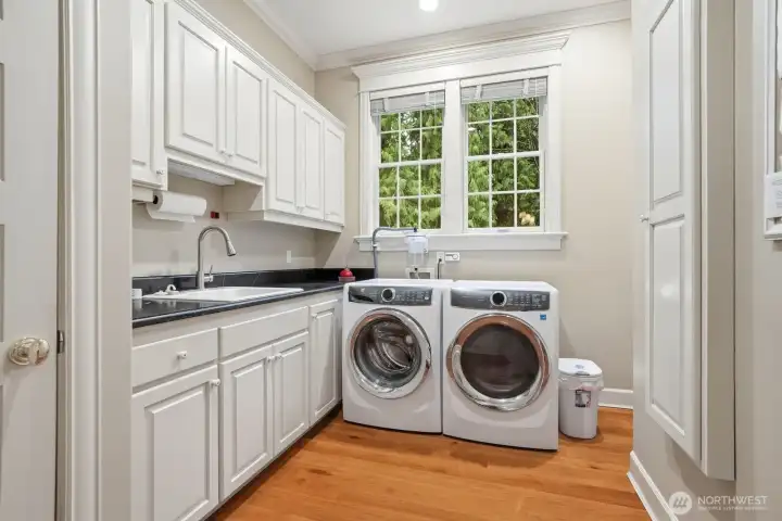 On the main level off the kitchen is the large laundry room with lots of cream cabinetry, newer Electrolux washer and dryer and utility sink.
