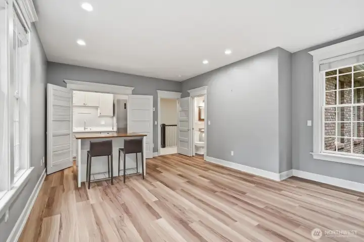 Behind double doors is a hidden kitchenette with full size refrigerator and dishwasher; this area makes a great guest or MIL area.