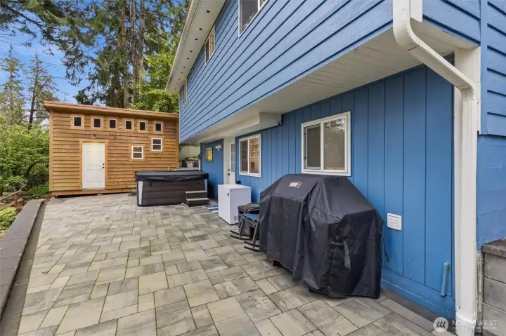 Driveway and back patio features lighting under wall cap. Staircase beyond  hardscape to firepit.