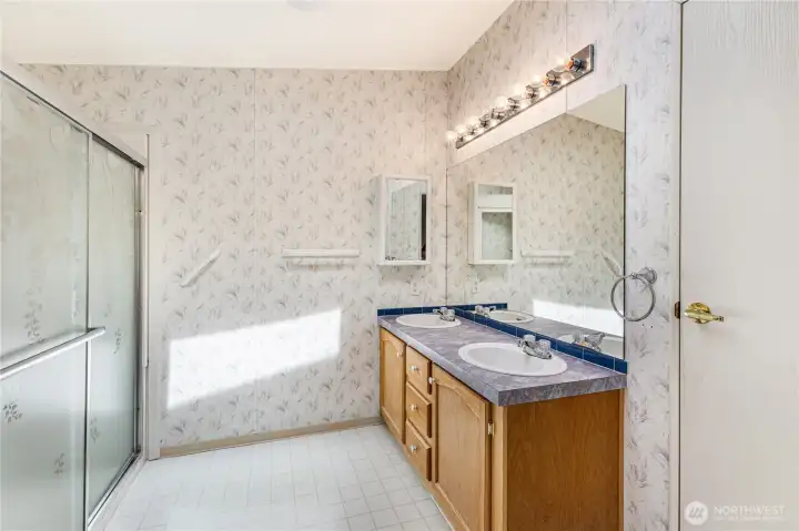 Primary en-suite bath with dual sinks and easy access shower.