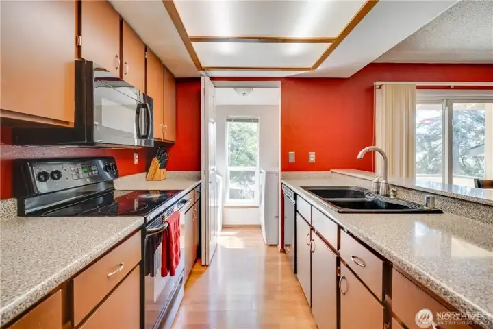 Kitchen with ample cabinet storage, spacious countertops, breakfast bar, and open-concept design in a move-in ready 2-bedroom condo.
