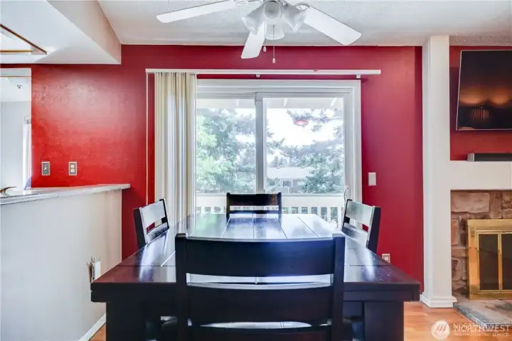 Dining area with sliding glass doors, private deck access, natural light, and open-concept floor plan in a move-in ready 2-bedroom condo.