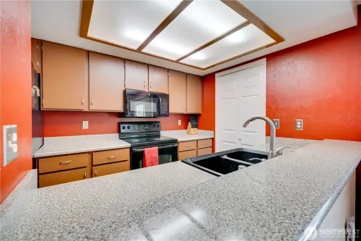 Spacious kitchen with abundant cabinet storage, breakfast bar, ample counter space, and open-concept layout in a move-in ready 2-bedroom condo.