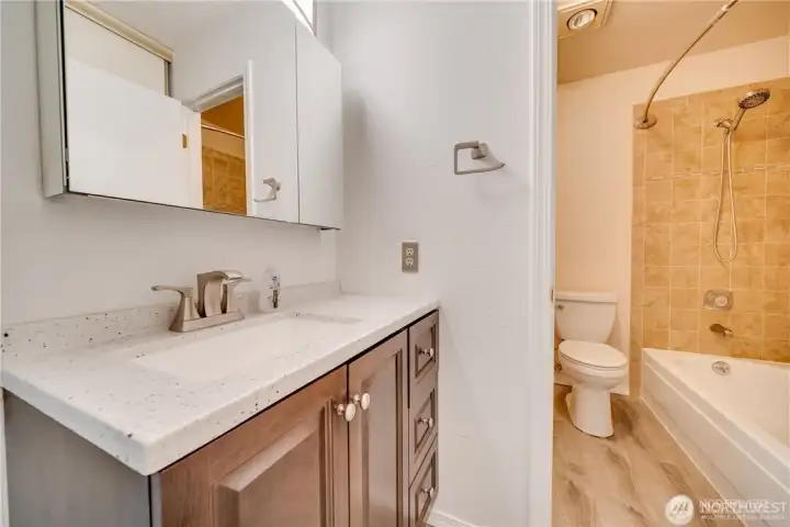 Updated bathroom with modern vanity, solid-surface countertop, upgraded fixtures, and tub/shower combination in a move-in ready 2-bedroom condo.