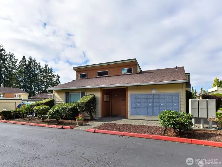 Community clubhouse and resident amenities building surrounded by landscaped grounds in a well-maintained condominium community.