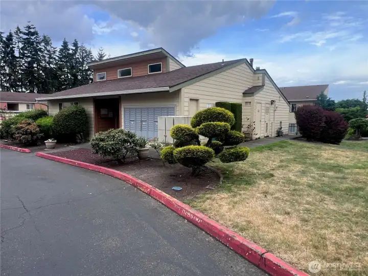 Community clubhouse surrounded by landscaped grounds and resident amenities in a well-maintained condominium community.