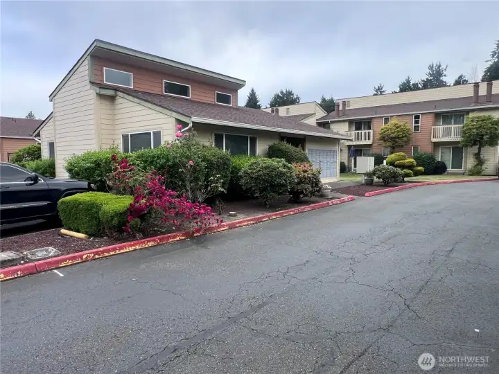 Community clubhouse surrounded by landscaped grounds and resident amenities in a well-maintained condominium community.