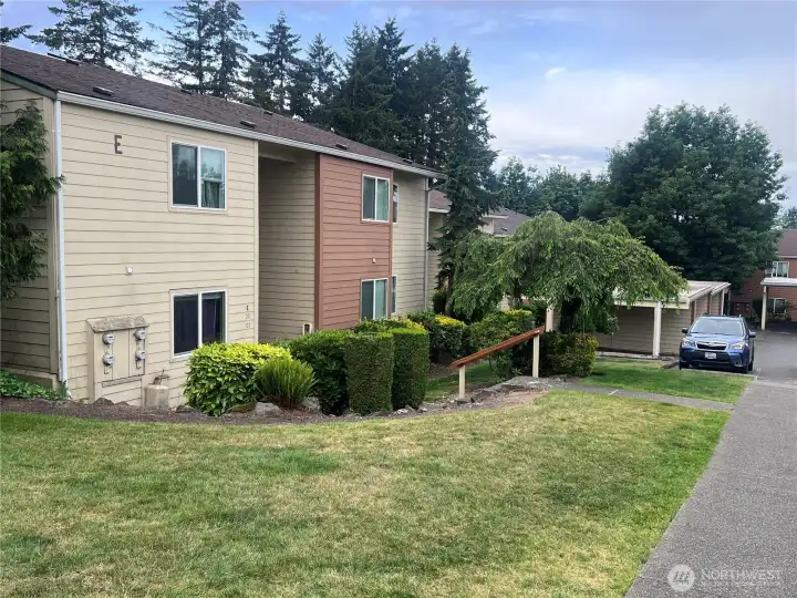 Landscaped condominium community with open green space, mature trees, and well-maintained grounds in a peaceful residential setting.