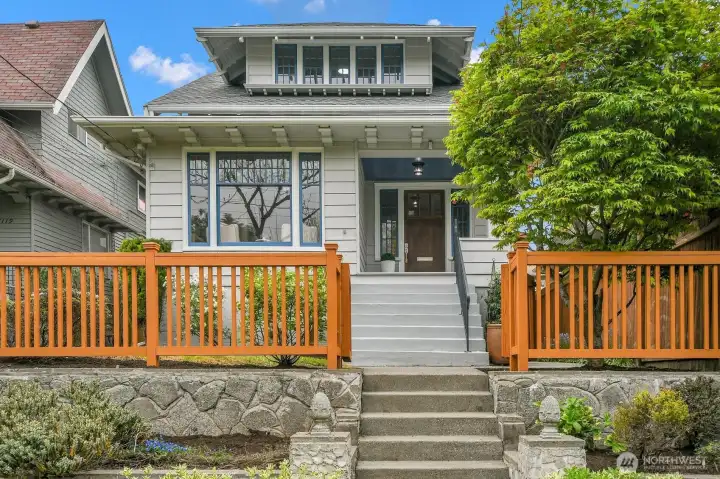 Classic Craftsman sits above the street over looking a matured treelined community...