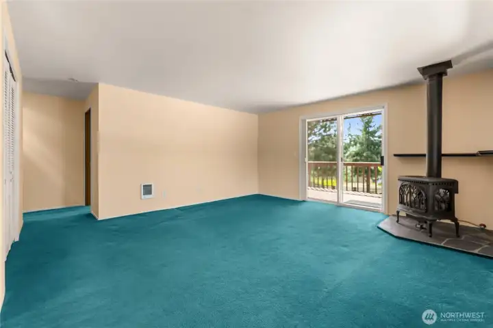 Spacious living room featuring propane stove and large windows overlooking the grounds. Spacious living room featuring propane stove and large windows overlooking the grounds.
