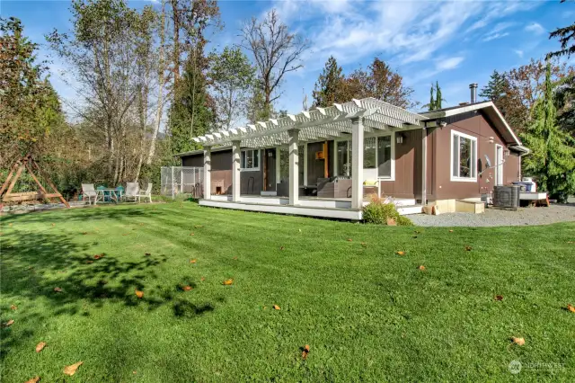 The back deck hosts a beautiful pergola and shade cover, swings and firepit.