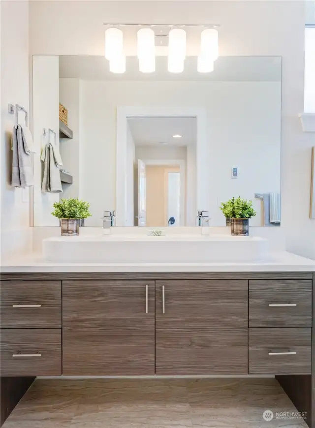 Primary bathroom of one of the Avenue plans.  All homes have primary bathrooms that feature walk in tiled showers + built in shelving for storage + modern cabinetry + natural light + quartz counters and Grohe fixtures.