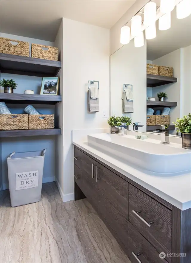 Primary bathroom of one of the Avenue plans.  All homes have primary bathrooms that feature walk in tiled showers + built in shelving for storage + modern cabinetry + natural light + quartz counters and Grohe fixtures.