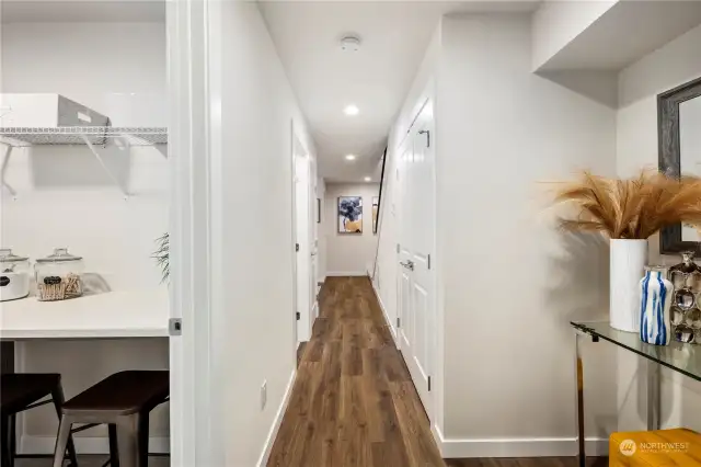 View of the entry (main level) looking down the hallway from the spacious bedroom.  A full walk in laundry is to the left, 3/4 bathroom and additional closets on both the left and right of this hallway.