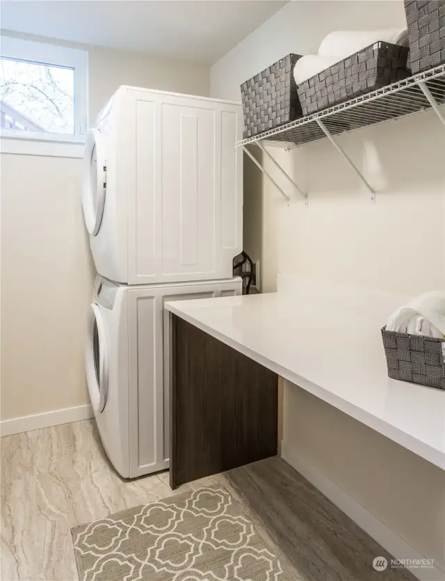 Full size washer and dryer (not included) fit in this large walk in laundry room.  Quartz countertop with storage underneath.