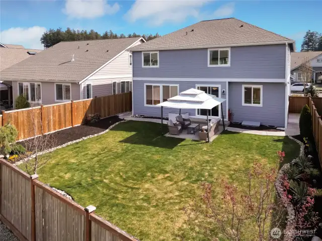 Beauitfully landscaped back yard with additional stone pathways on both sides of home.