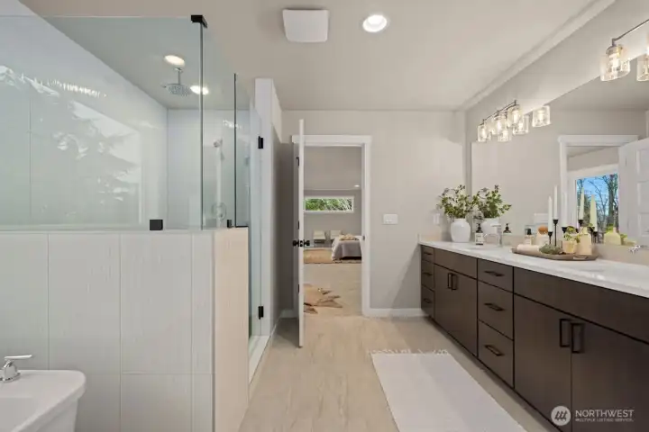 Luxurious bathroom in Owner's Suite with double sinks, walk-in shower with dual showerhead system, and lounge tub.