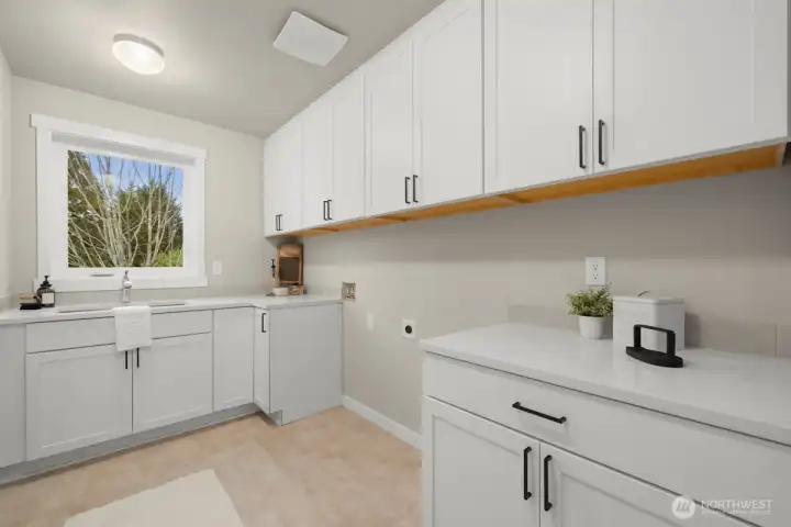 Upper level laundry with folding counter and utility sink.