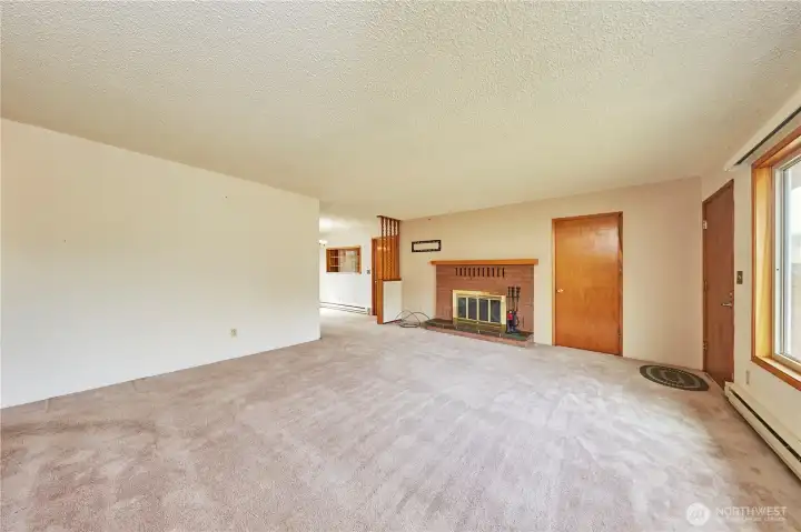 Welcome Home! Front Door and Large Picture Window to Right; Coat Closet and Wood Burning Fireplace And Wall to Wall Carpeting Greet You.