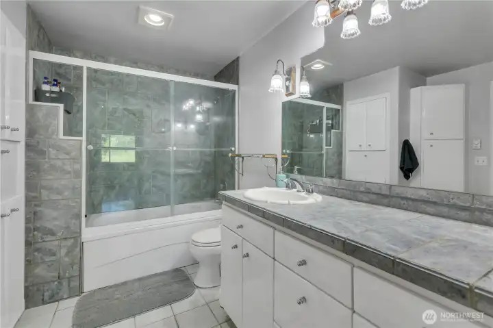 Full bathroom with oversized vanity and tile finishes.