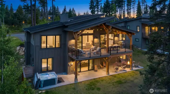 Back exterior twilight view with expansive outdoor living space for gathering and dining. Back exterior twilight view with expansive outdoor living space for gathering and dining.