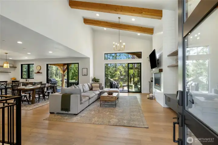 Light-filled great room framed by expansive windows. Soaring ceilings with exposed beams create dramatic volume. Light-filled great room framed by expansive windows. Soaring ceilings with exposed beams create dramatic volume.