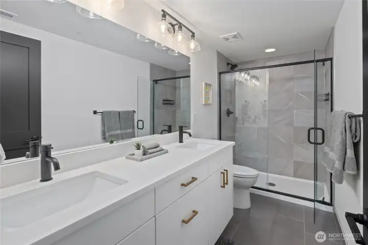 Lower level bathroom with dual sink vanity and large shower. Lower level bathroom with dual sink vanity and large shower.